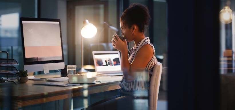 woman drinking a cup of coffee at her desk